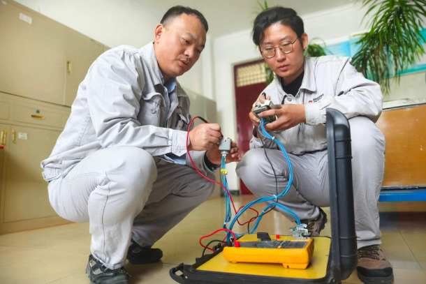 圖為配電班QC小組成員對自主研制的試驗輔助裝置進行調(diào)試.jpg